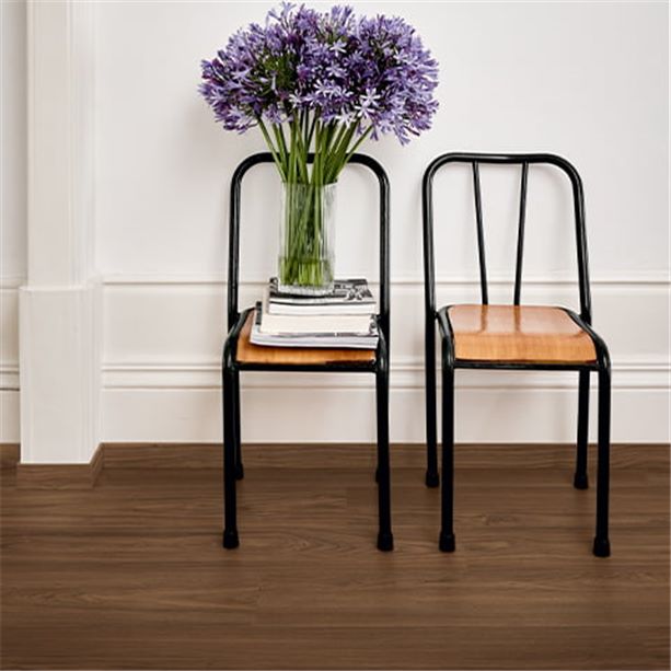 hallway with dark brown walnut flooring and two chairs with flowers